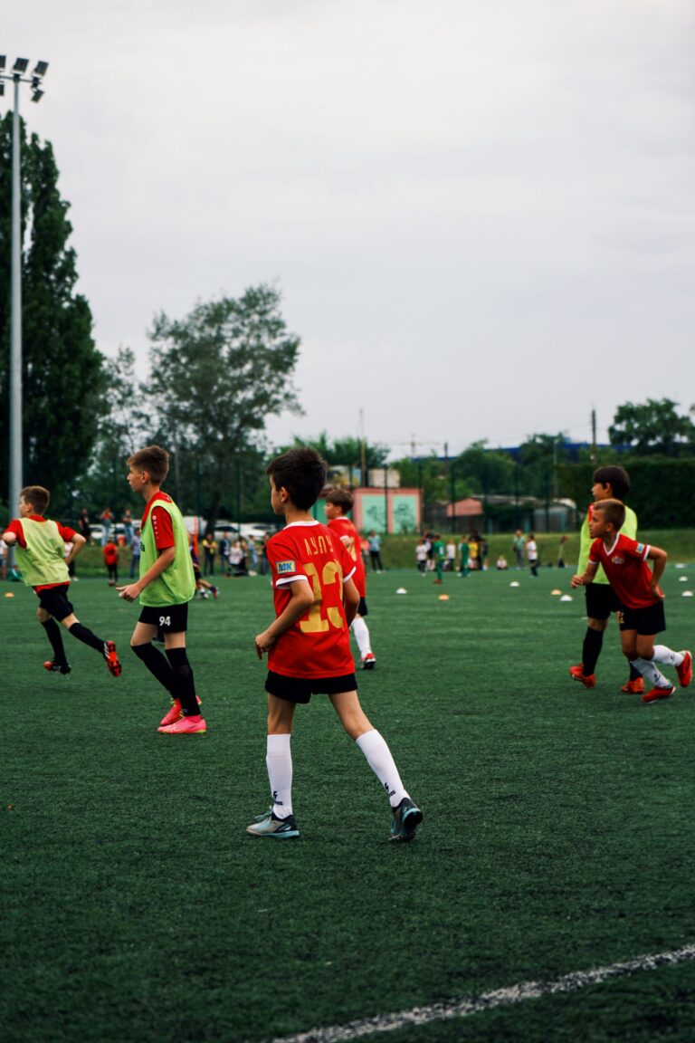Home Young kids playing soccer on a green field during the day. Engaged in a fun sporting activity.